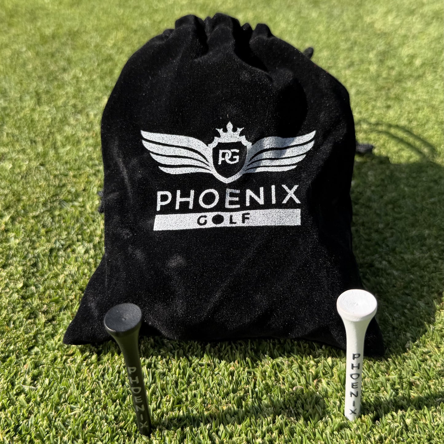 Phoenix Golf Pro Bamboo Golf Tees in black and white, and a black velvet pouch with Phoenix golf branding on in silver.