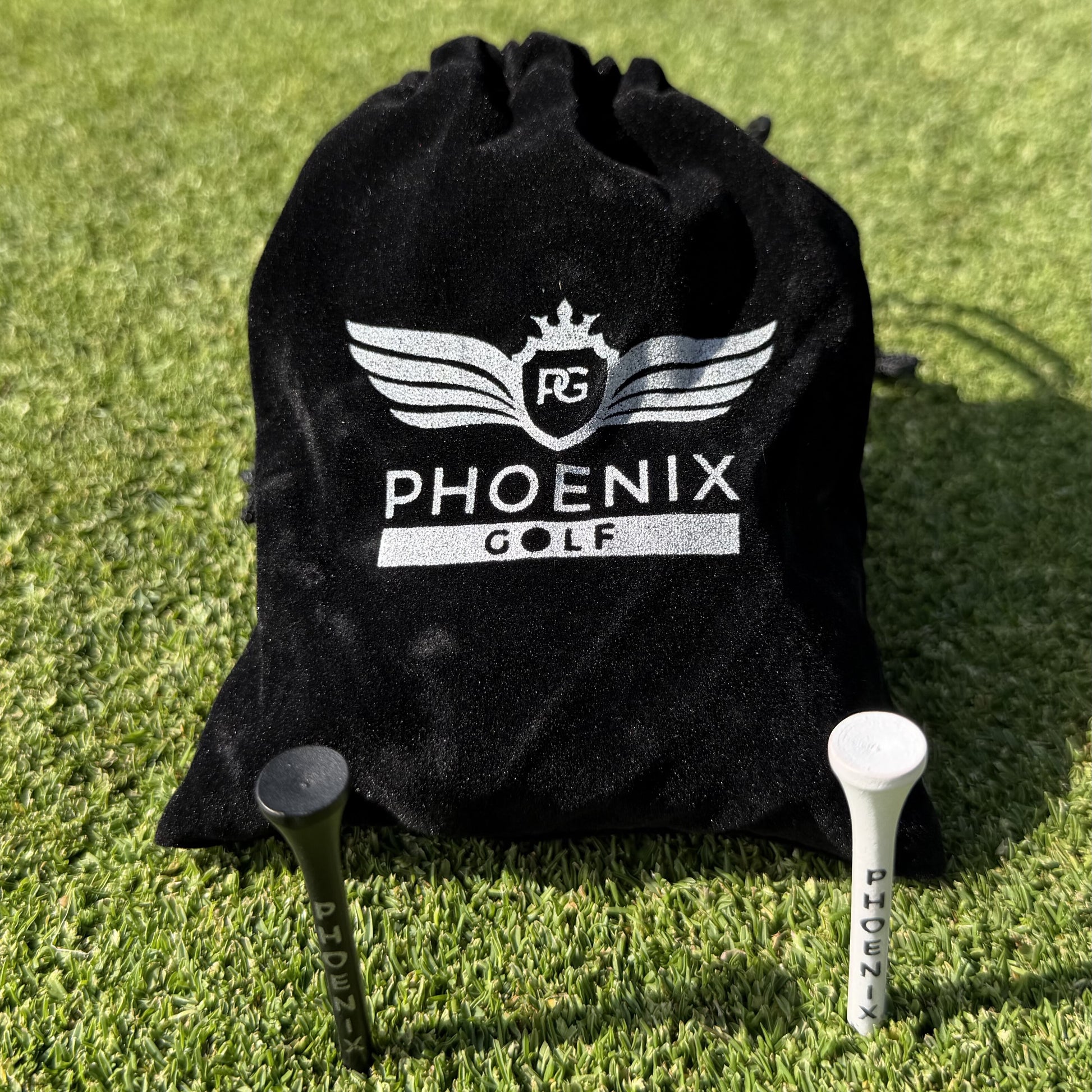 Phoenix Golf Pro Bamboo Golf Tees in black and white, and a black velvet pouch with Phoenix golf branding on in silver.